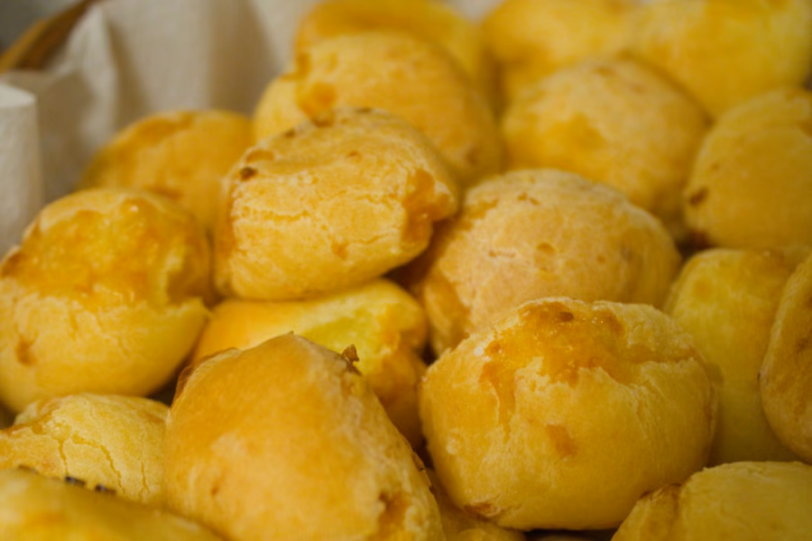 Cesta de pães de queijo dourados recém-assados